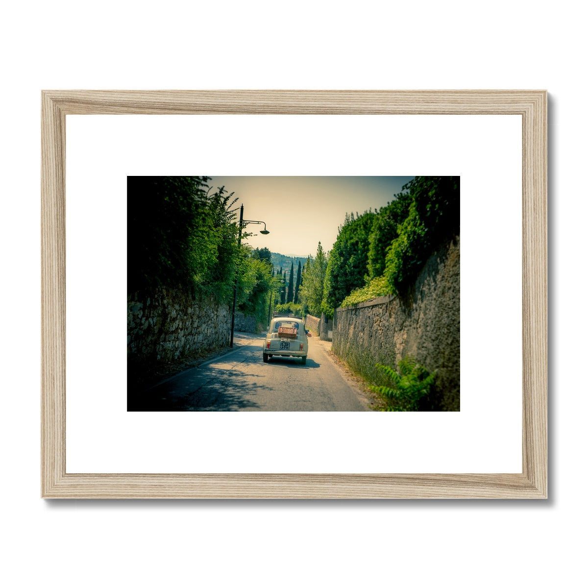Classic Fiat 500 car driving on a road in Florence, Italy. Framed & Mounted Print