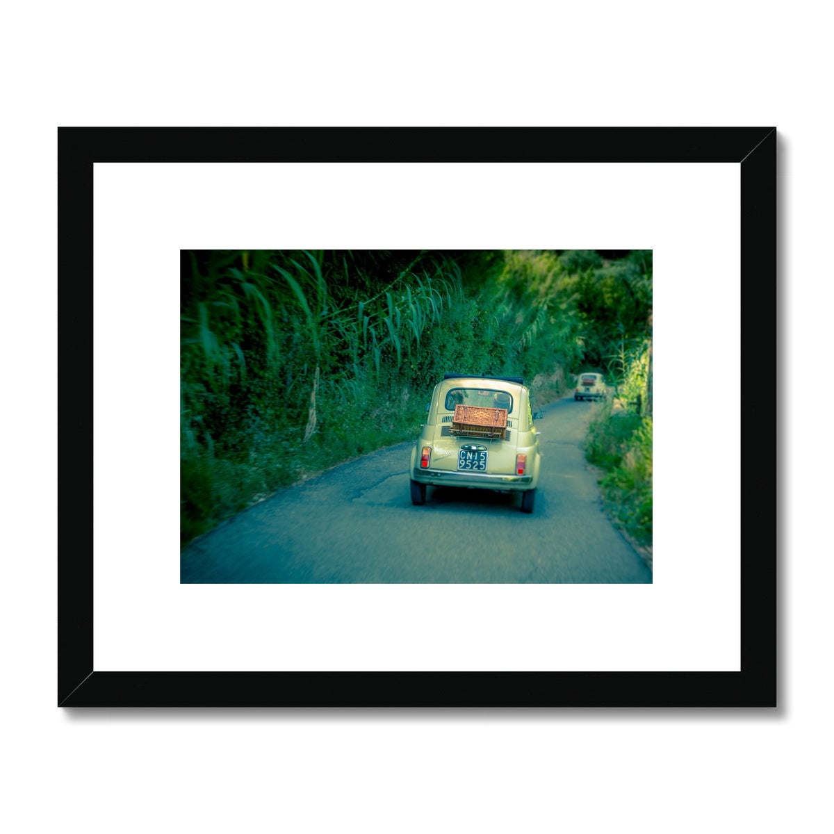 Classic Fiat 500 cars driving on a road in Florence, Italy.  Framed & Mounted Print