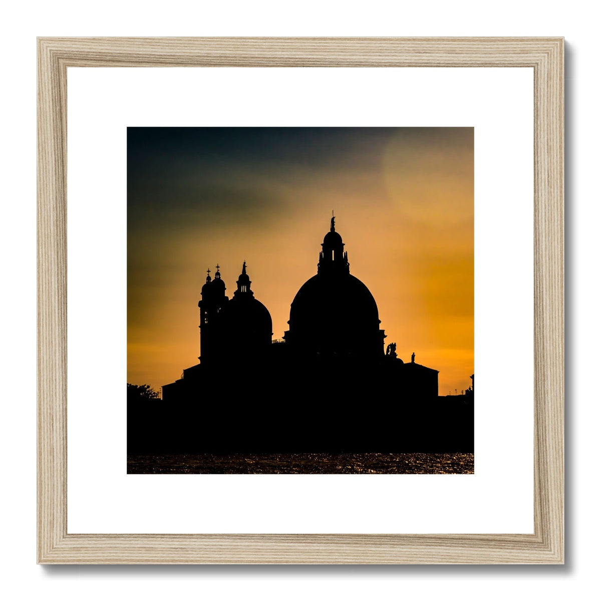 Silhouette of Santa Maria della Salute on the Grand Canal in Venice against a golden sky at sunset. Italy. Framed & Mounted Print