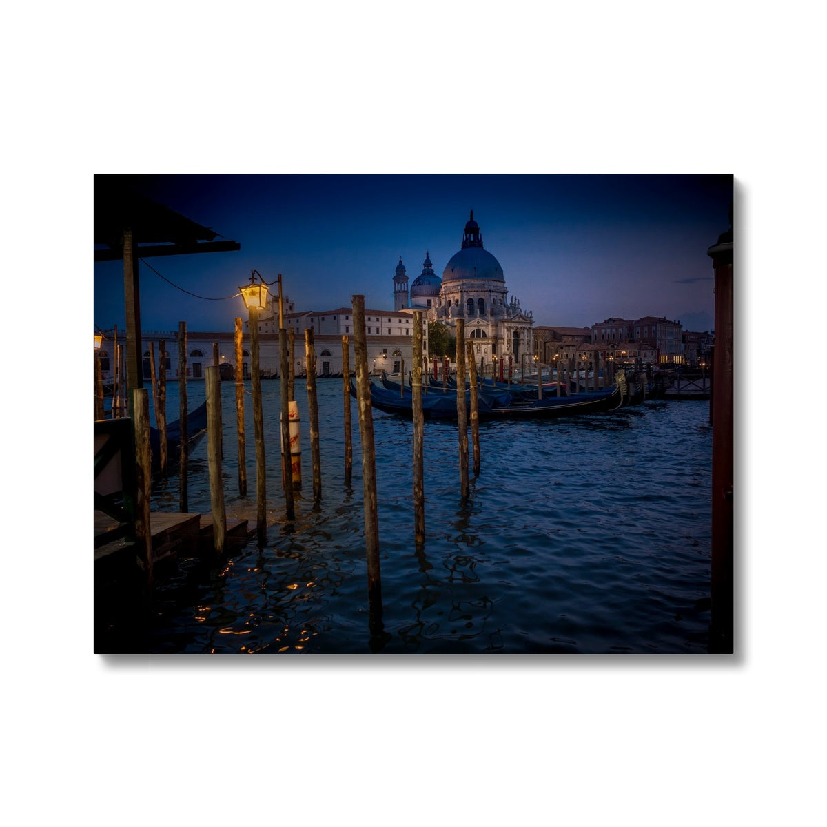 Gondolas moored for the night on the Grand Canal with the church of Santa Maria della Salute in the background. Venice, Italy. - Canvas