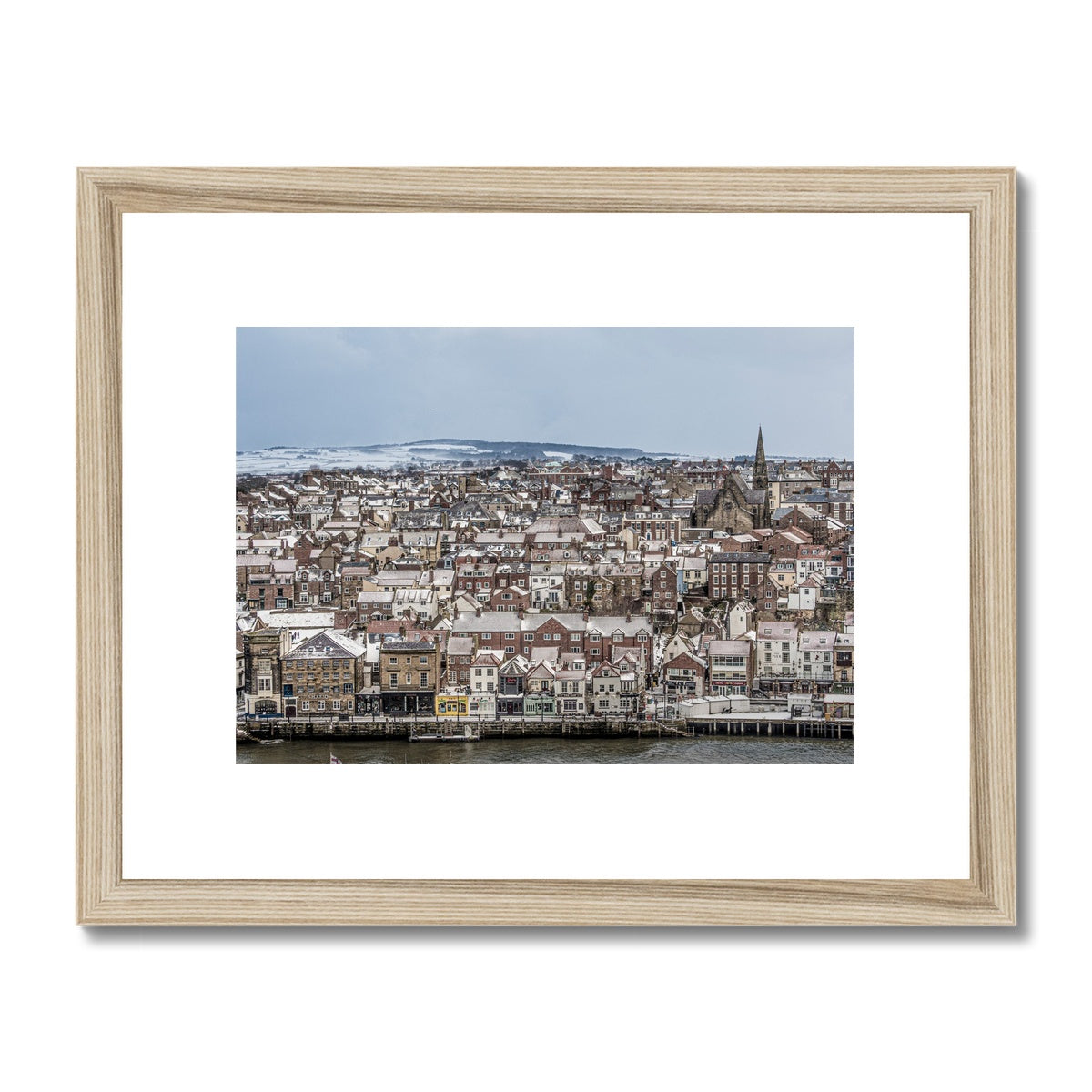 View of Whitby town centre in snow from St Mary's Church, Whitby, UK. Framed & Mounted Print