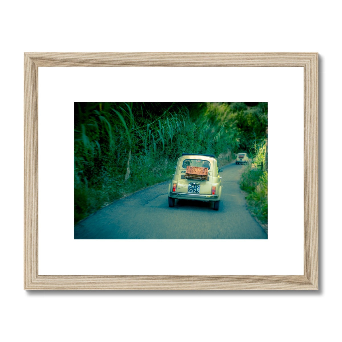 Classic Fiat 500 cars driving on a road in Florence, Italy.  Framed & Mounted Print