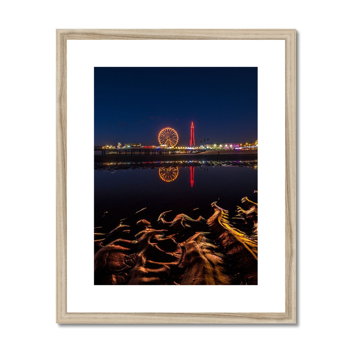 Blackpool Tower and Central Pier at night, with reflection of illuminations in water on the beach  UK. Framed & Mounted Print