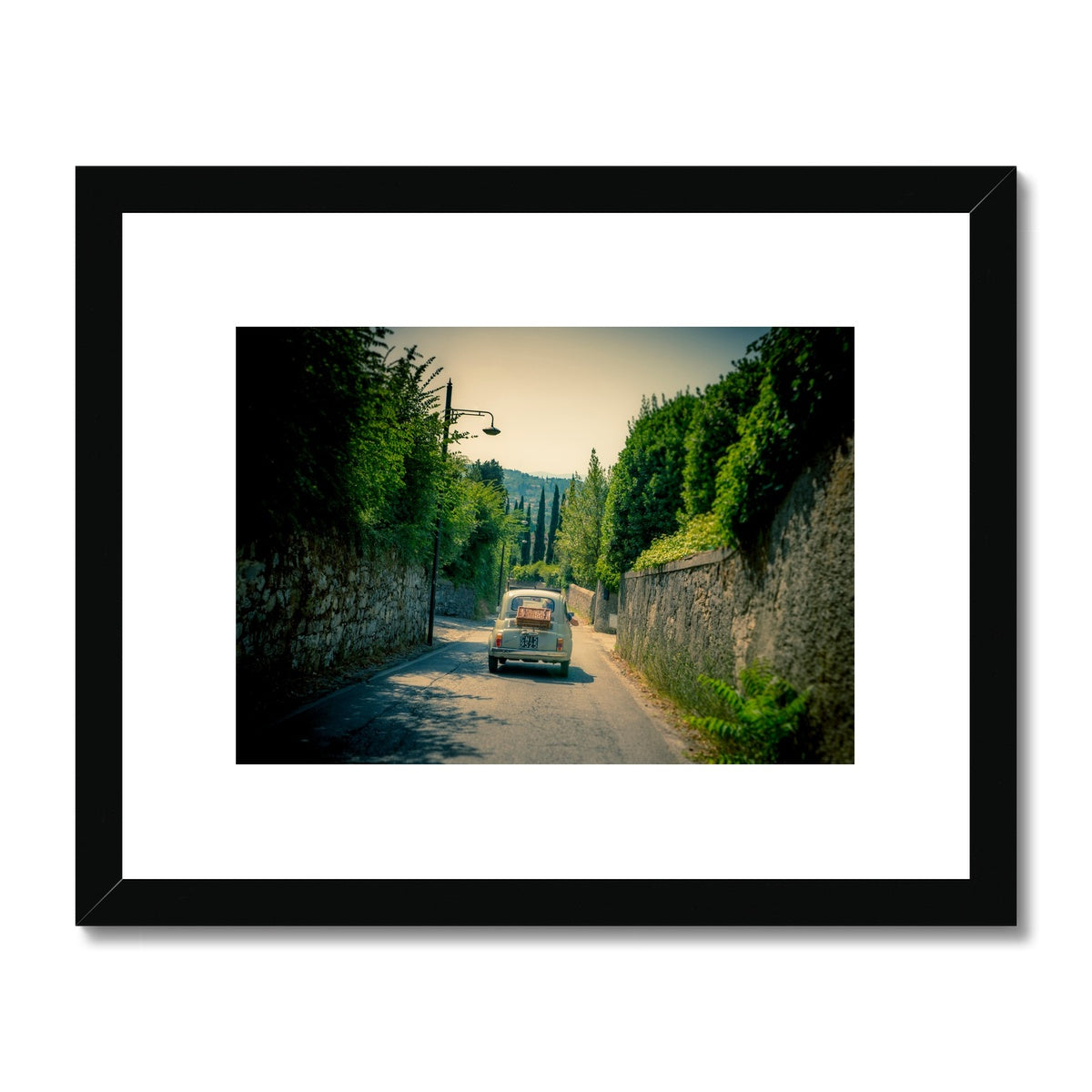 Classic Fiat 500 car driving on a road in Florence, Italy. Framed & Mounted Print