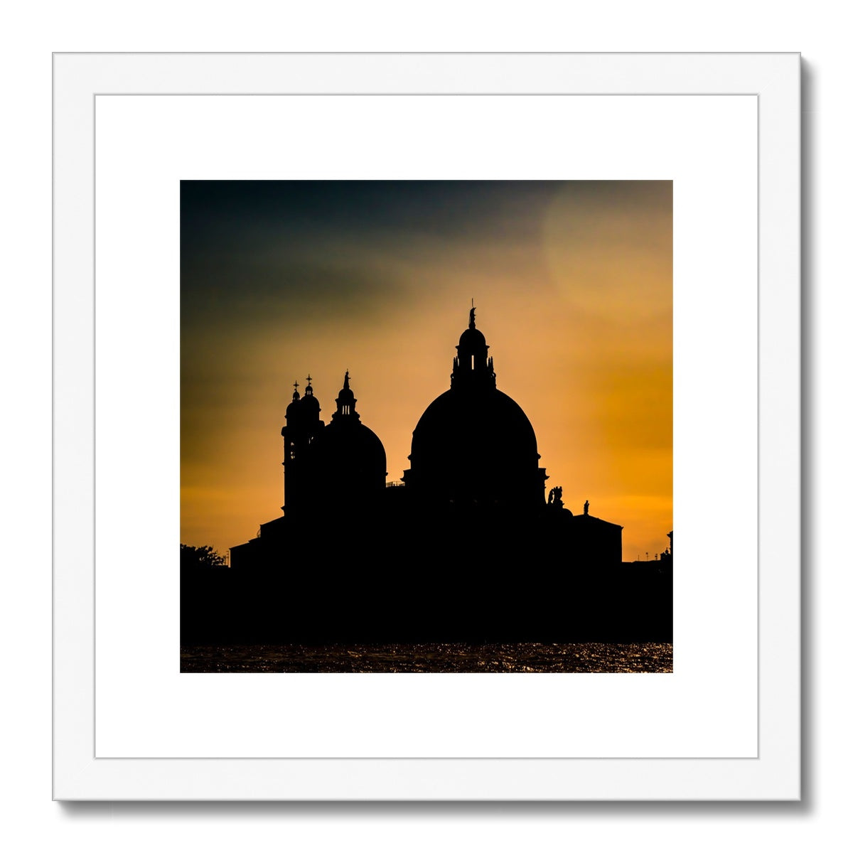 Silhouette of Santa Maria della Salute on the Grand Canal in Venice against a golden sky at sunset. Italy. Framed & Mounted Print