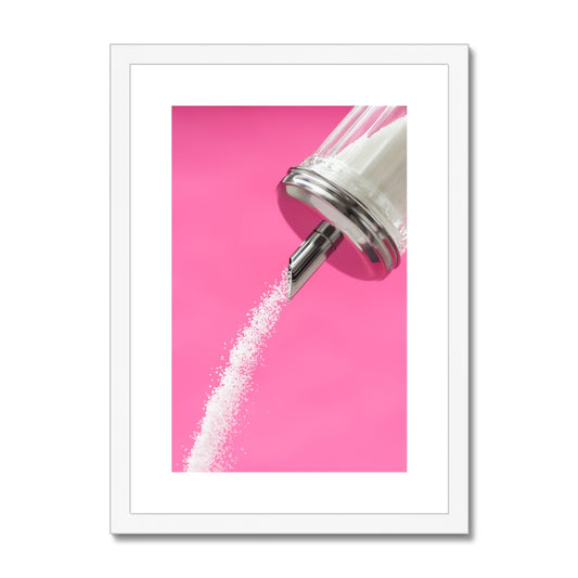 Sugar dispenser pouring against pink background Framed & Mounted Print