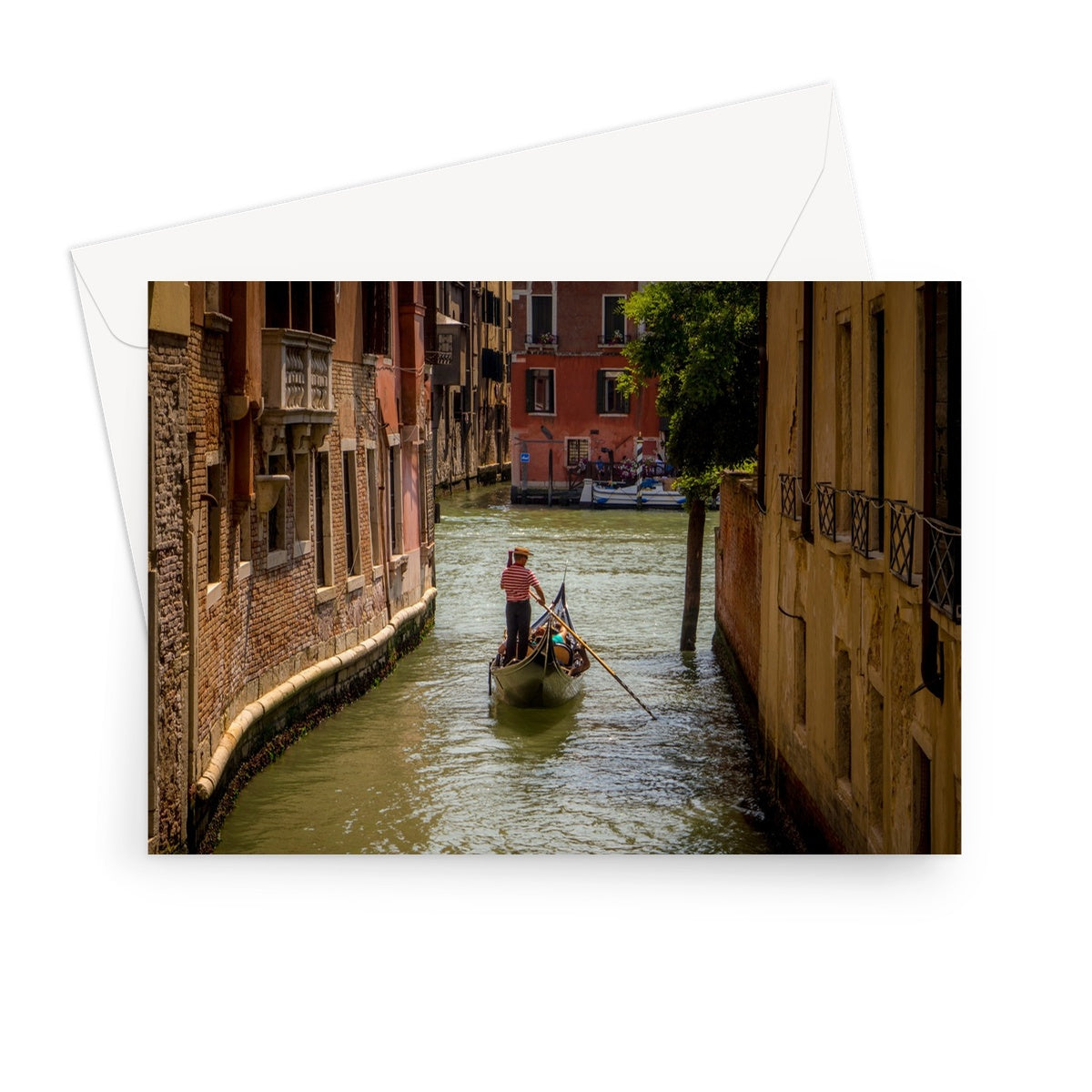 Gondola with gondolier wearing a traditional boater hat and striped top on a  canal in Venice. Italy. Greeting Card