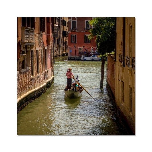 Gondola with gondolier wearing a traditional boater hat and striped top on a  canal in Venice. Italy. Fine Art Print