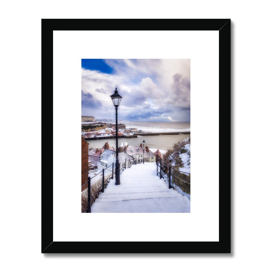 Snow covered steps leading down from St Mary's Church, Whitby, UK. Framed & Mounted Print