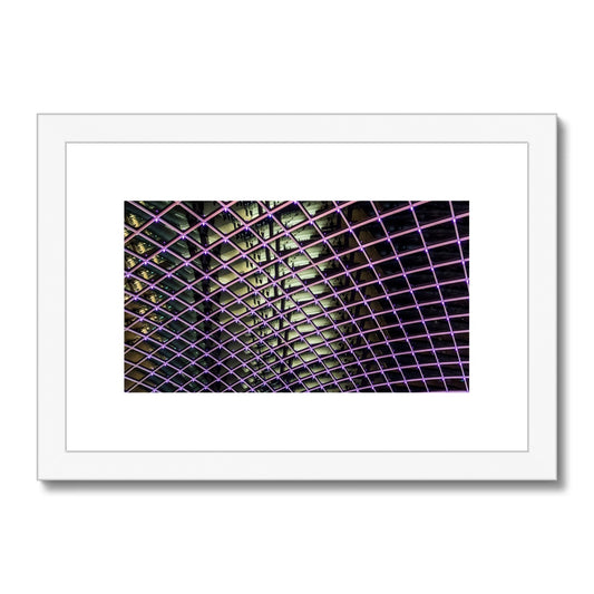 Illuminated grid pattern on a glass ceiling captured at night Framed & Mounted Print