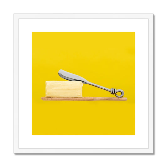 Homemade butter on wooden paddle with butter knife and yellow background. Framed & Mounted Print