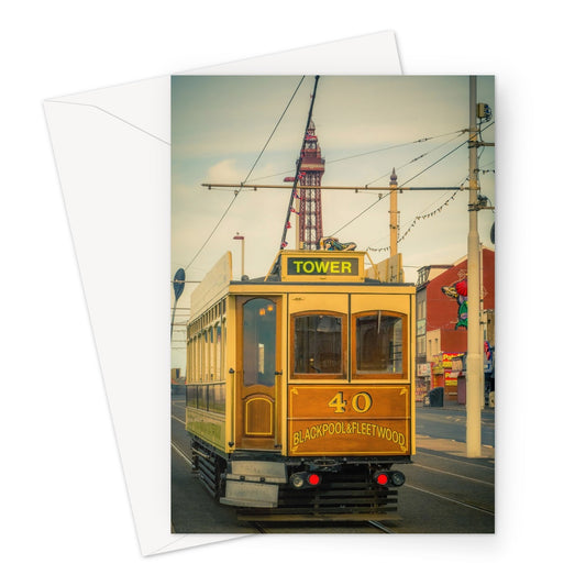 Traditional tram running along seafront promenade with Blackpool Tower in background - Blackpool,UK. Greeting Card