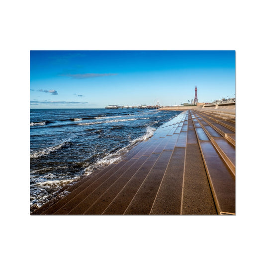 Blackpool's stone stepped sea defences with Blackpool Tower and Central Pier in the distance, Blackpool, UK. Fine Art Print