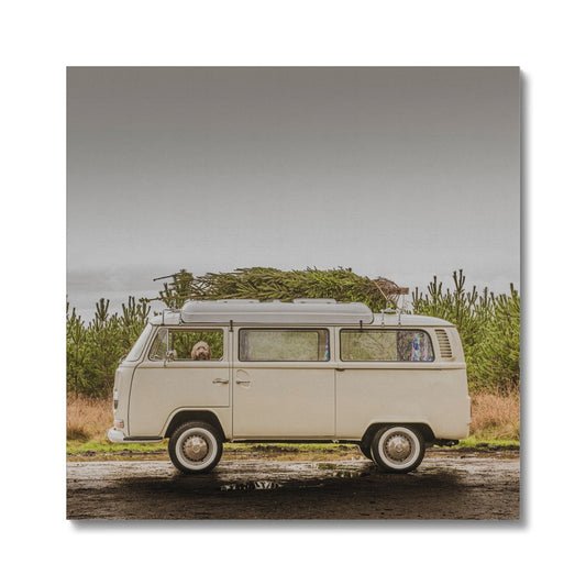 1972 VW Bay Window Campervan parked with with Christmas tree on roof and Cockapoo dog looking out of window. Canvas