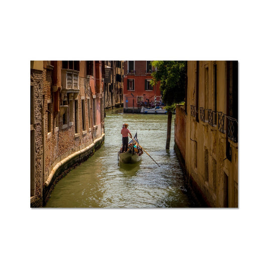 Gondola with gondolier wearing a traditional boater hat and striped top on a  canal in Venice. Italy. Fine Art Print