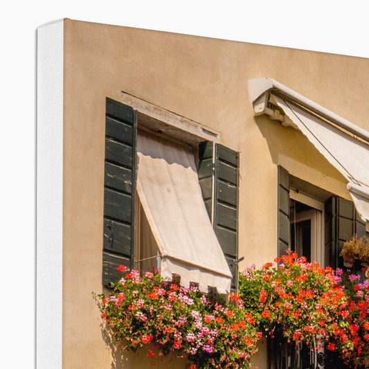 Traditional canal-side cream-rendered house with shuttered windows and window boxes. Venice. Italy. Canvas