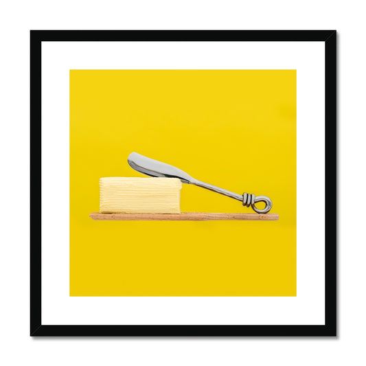 Homemade butter on wooden paddle with butter knife and yellow background. Framed & Mounted Print