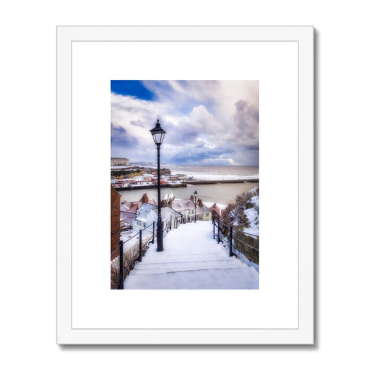 Snow covered steps leading down from St Mary's Church, Whitby, UK. Framed & Mounted Print