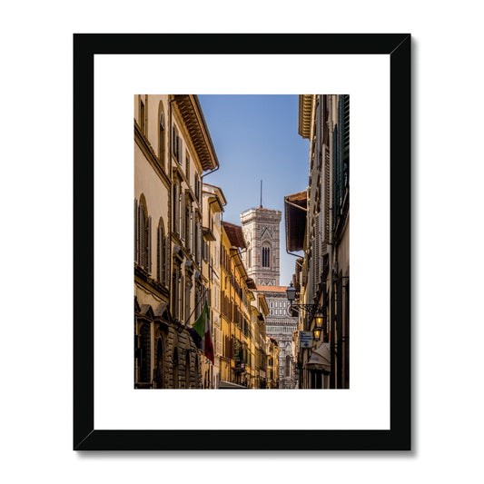 Giotto's Campanile glimpsed between buildings in the city of Florence, Italy. Framed & Mounted Print