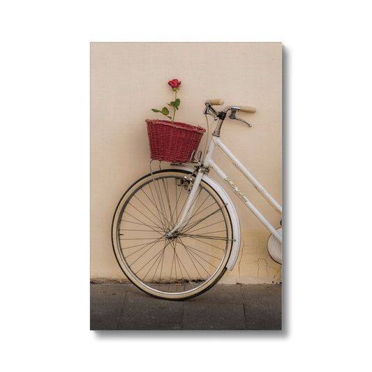 White bicycle parked against a  rendered wall with a red rose in its basket, Rome, Italy. Canvas